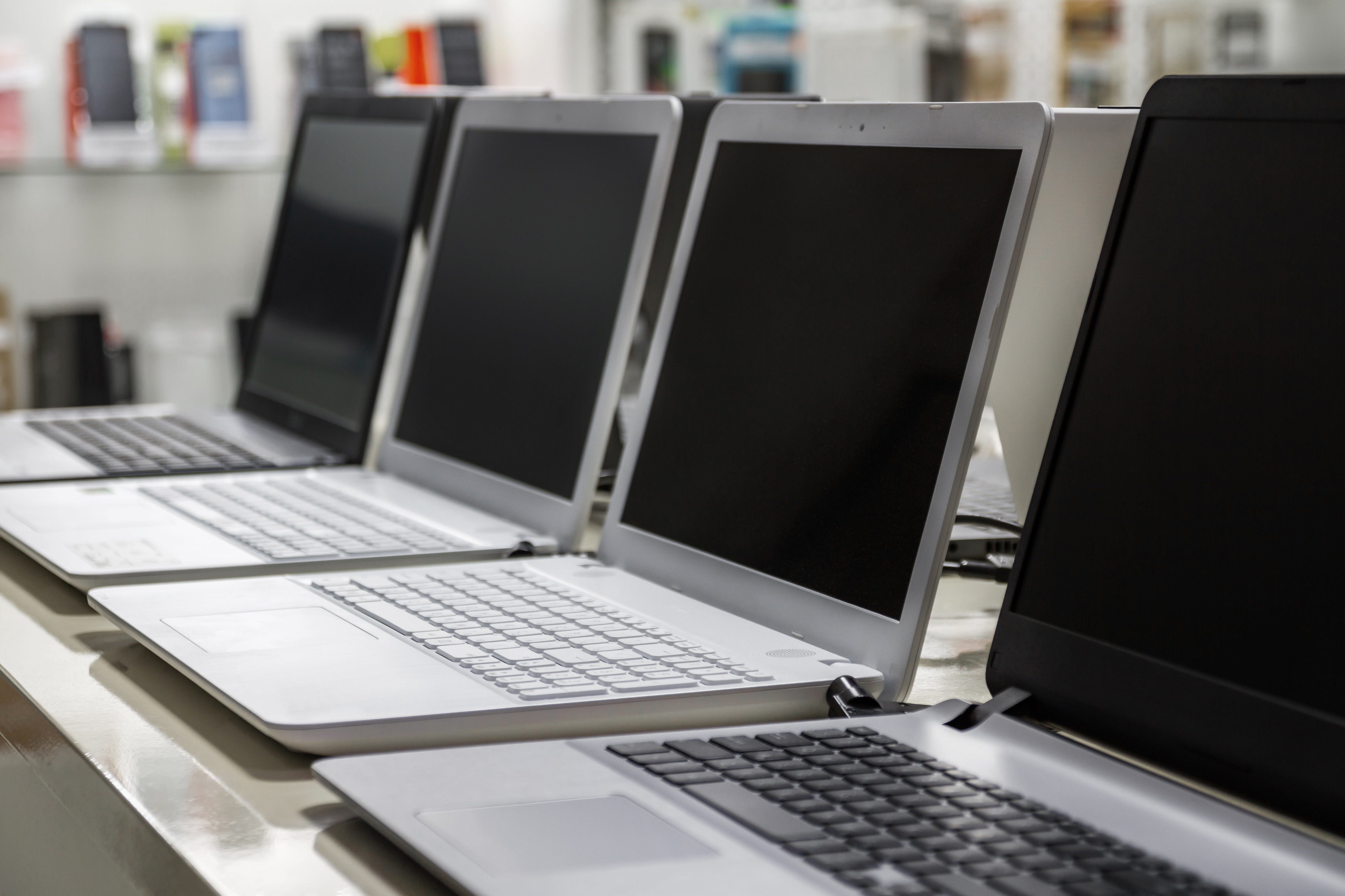 Rows of retired business laptops collected for secure data destruction, buyback, and recycling